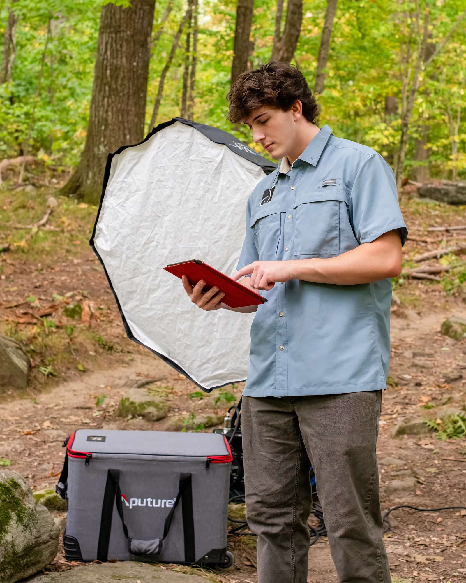 Chris Heart reviewing production notes on a tablet beside a portable light.
