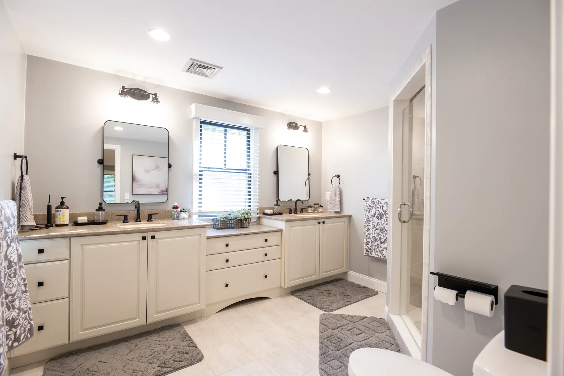 Primary bathroom with a double vanity and glass shower.