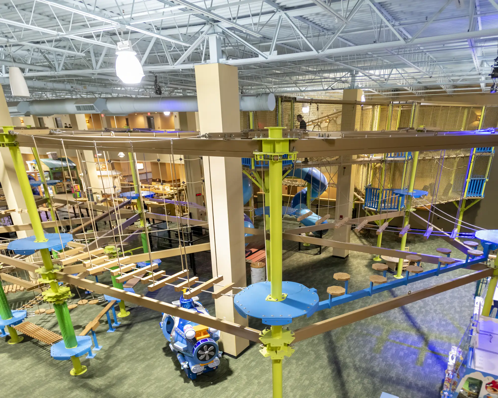 Overhead view of rope bridges, swinging planks, and platforms across the indoor course.