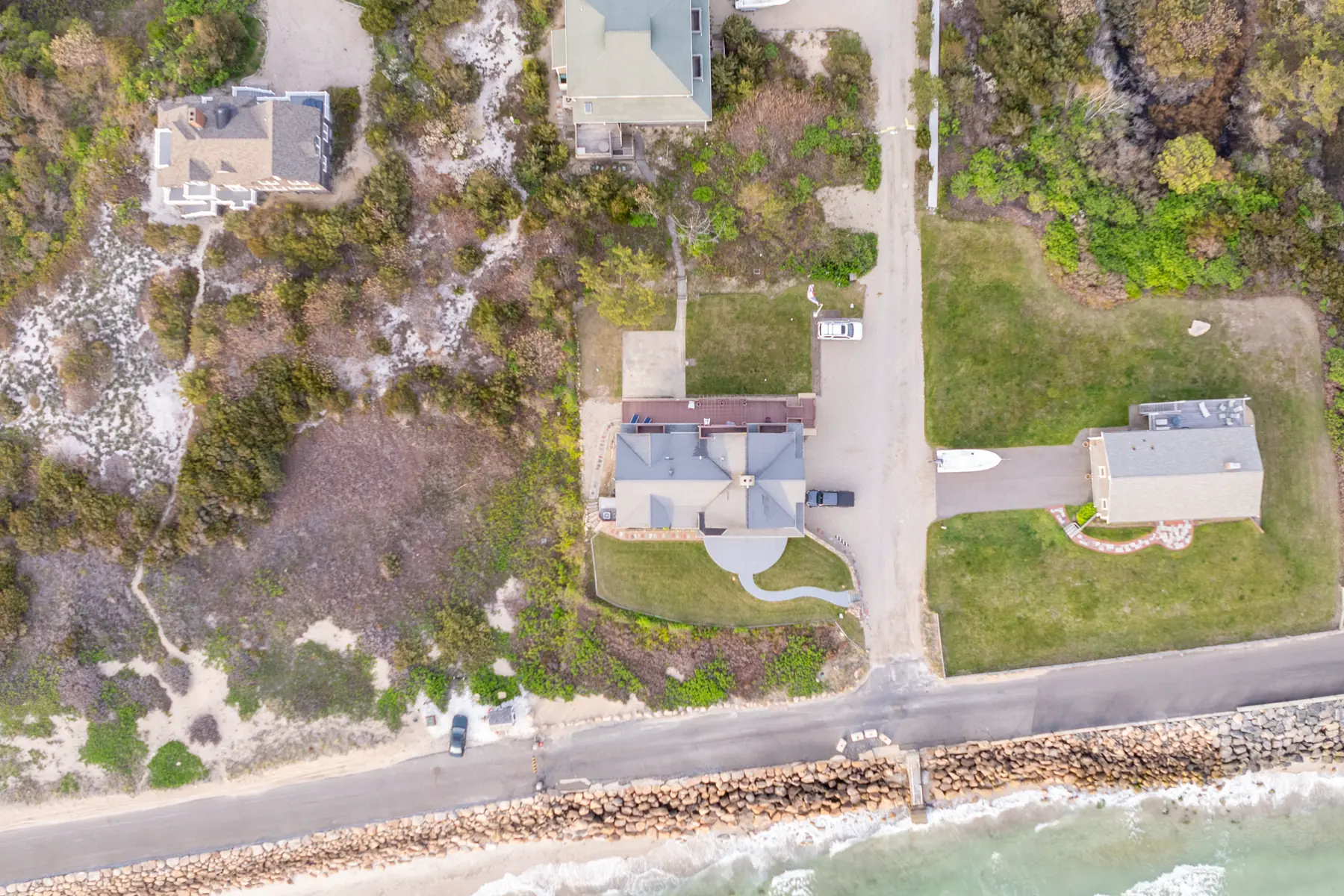 Top-down aerial view of the coastal home beside the shoreline.