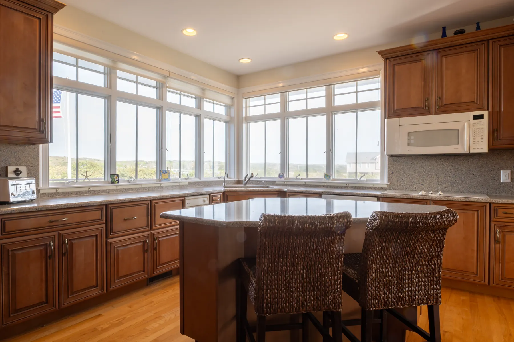 Wood-paneled kitchen with a central island and windows overlooking the coast.