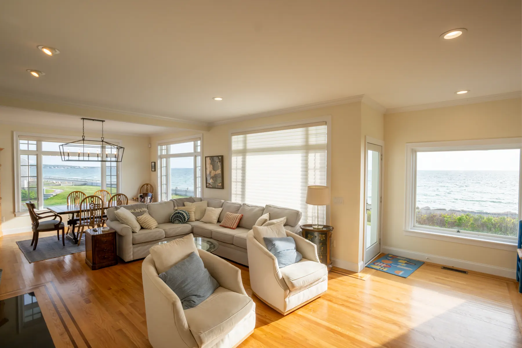Light-filled living and dining area with large windows facing the ocean.