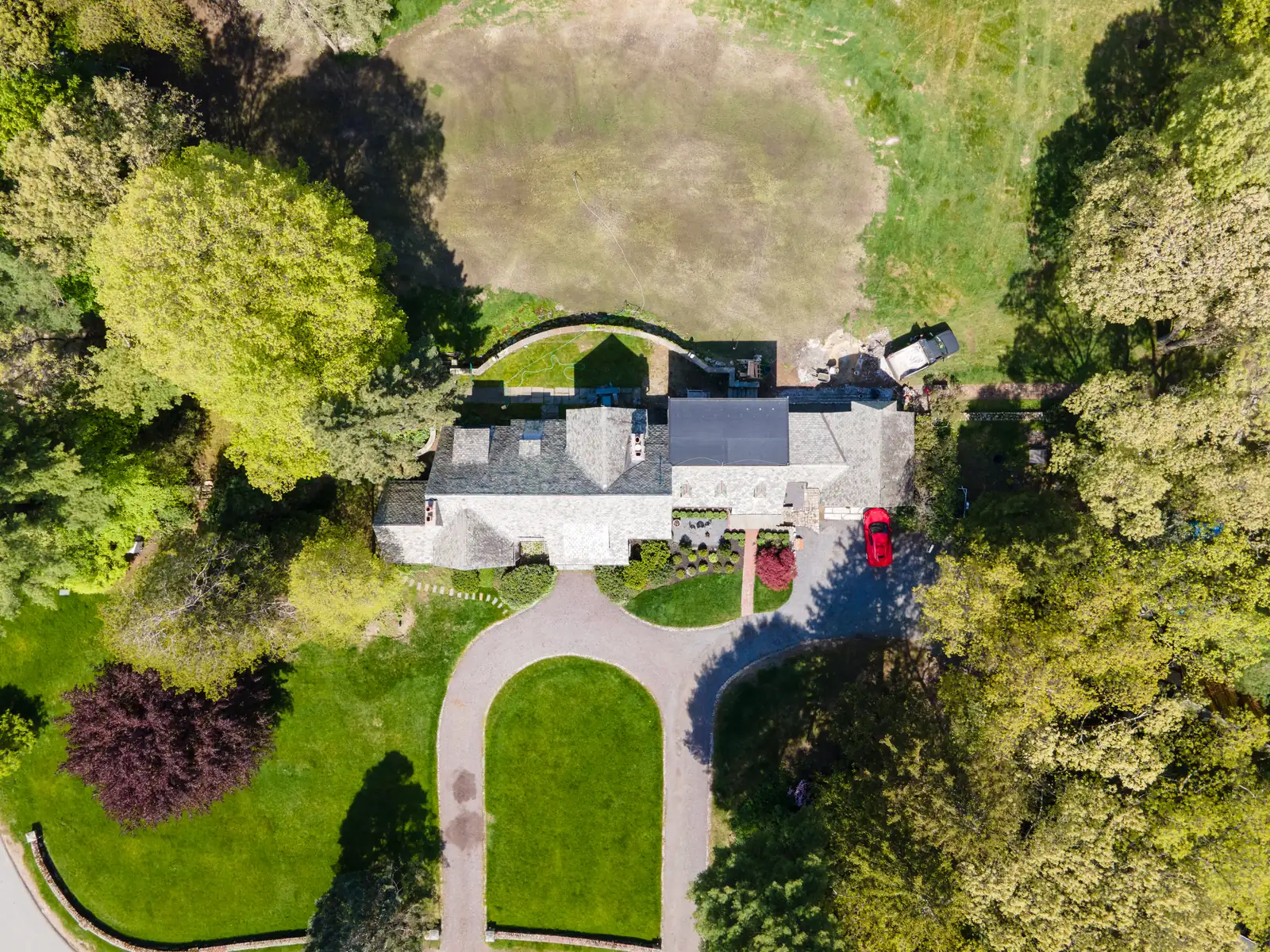 Top-down aerial view of the English Tudor home, circular drive, and surrounding trees.