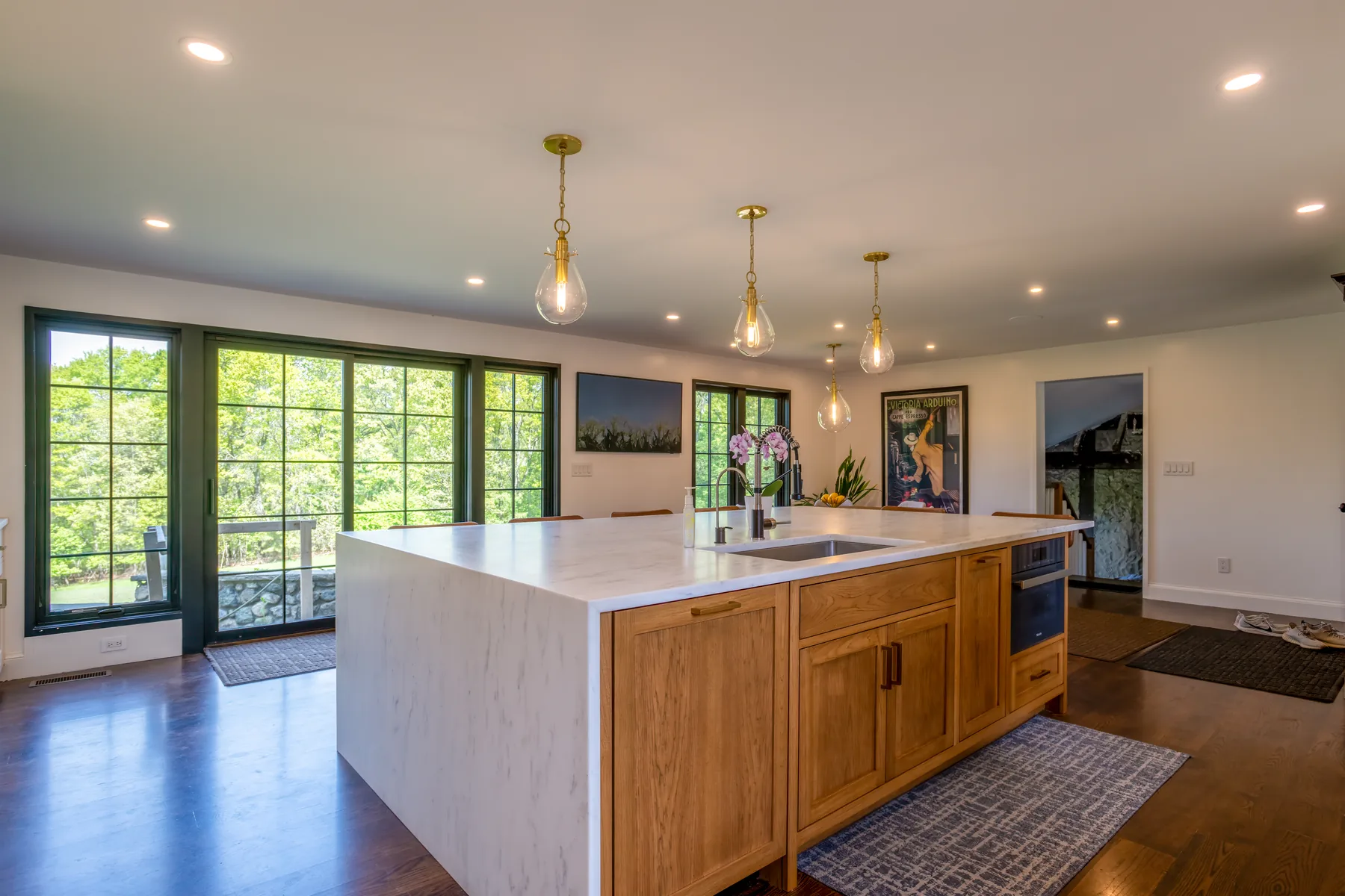 Kitchen island with wood cabinetry and a wall of glass doors facing the garden.