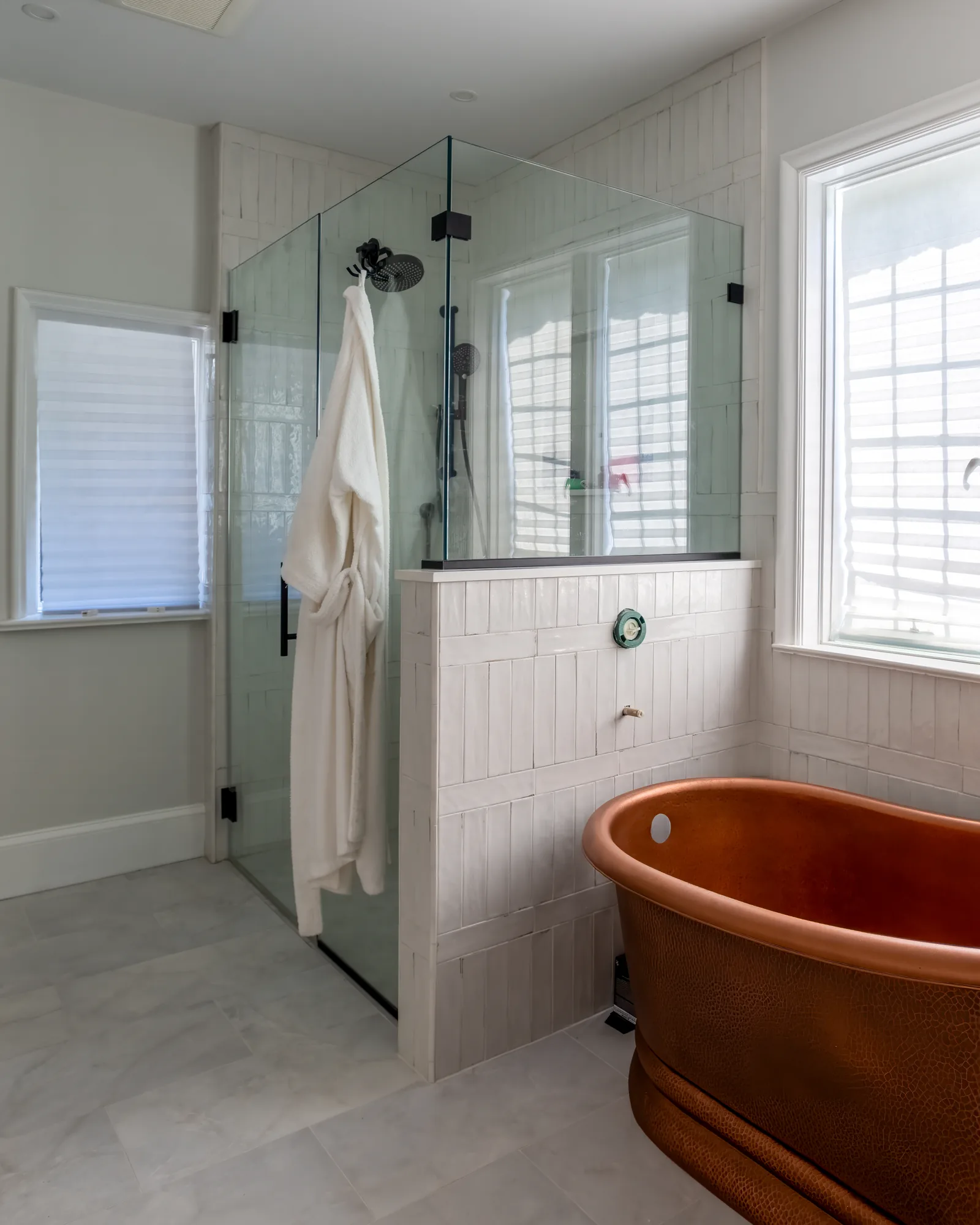 Primary bathroom with a copper soaking tub and glass shower.
