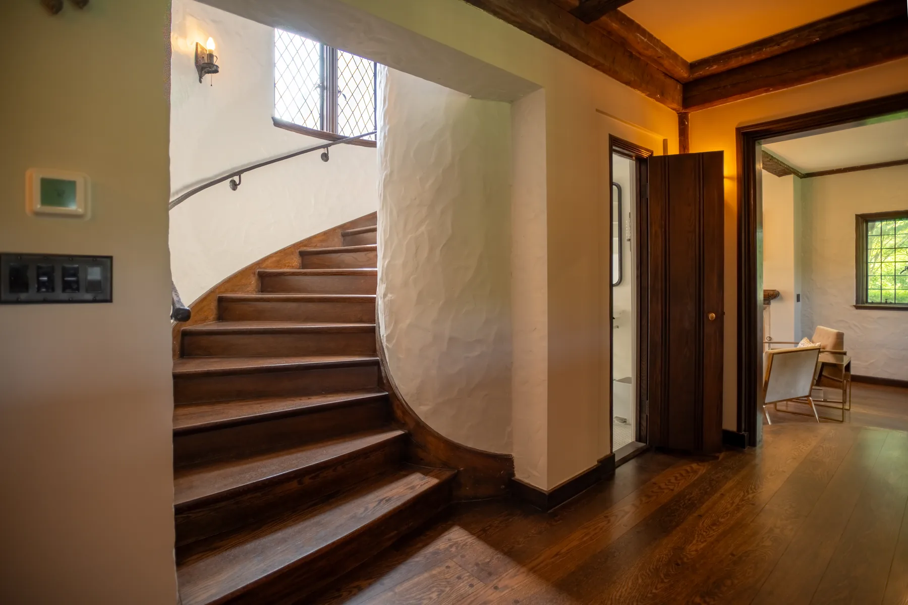 Wood staircase and arched entry hall inside the Tudor home.
