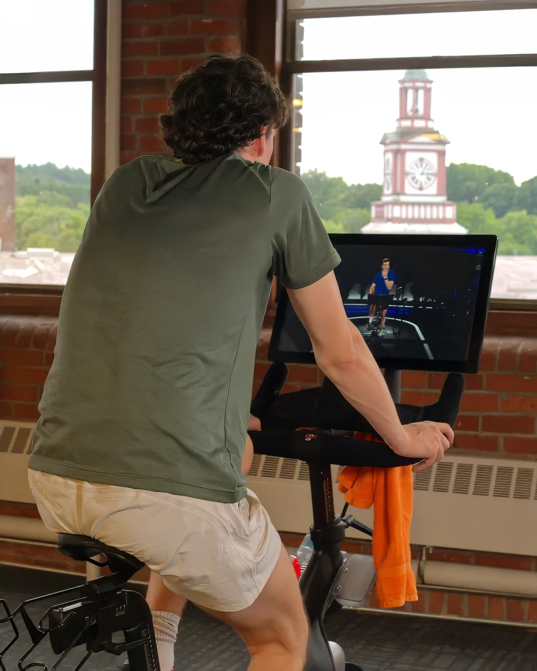 Rider using an indoor cycling machine fitted with the Gus Grips handlebar cover.