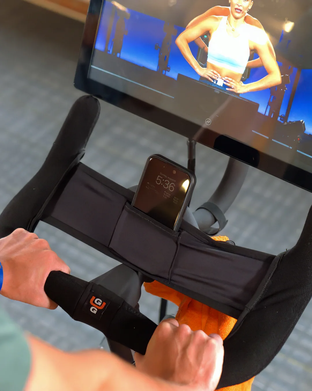 Side view of a rider holding the Gus Grips cover during an indoor cycling workout.