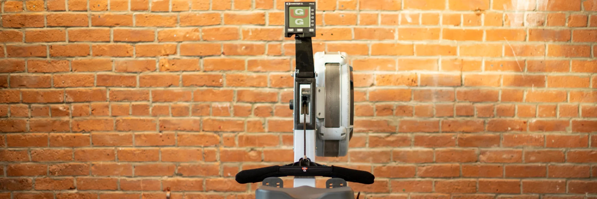 Front view of a rowing machine with the Gus Grips cover installed on its handle.