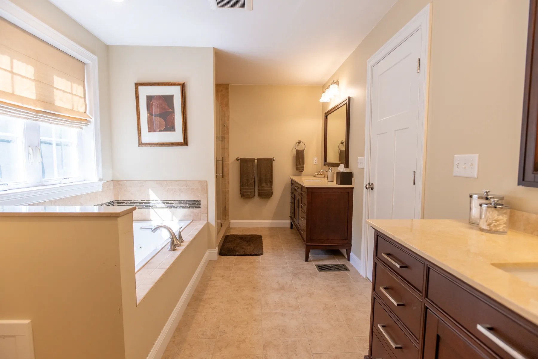 Primary bathroom with two vanities, a soaking tub, and a glass-enclosed shower.