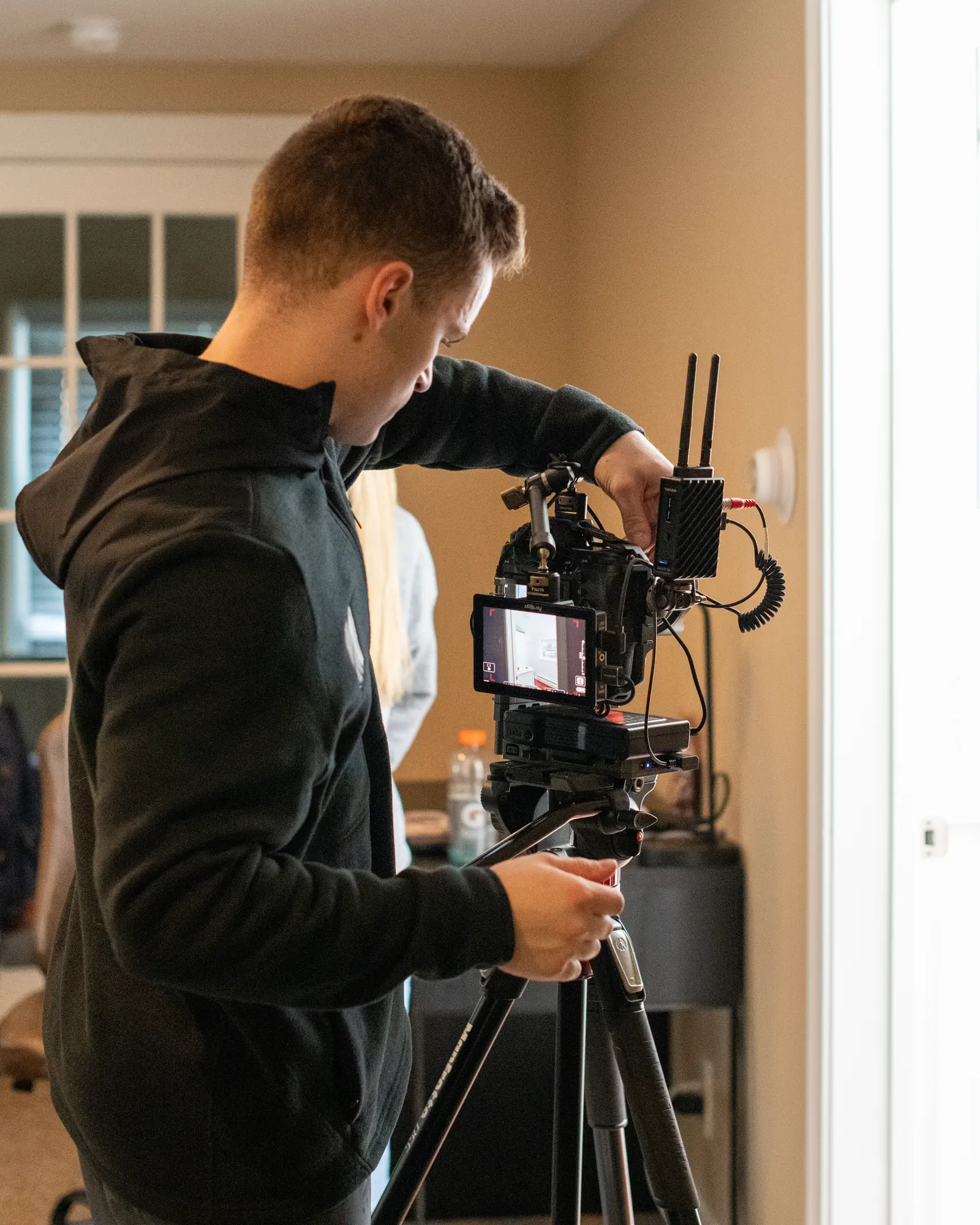 Kyle Soule adjusting a cinema camera during the Scholar Suites production.