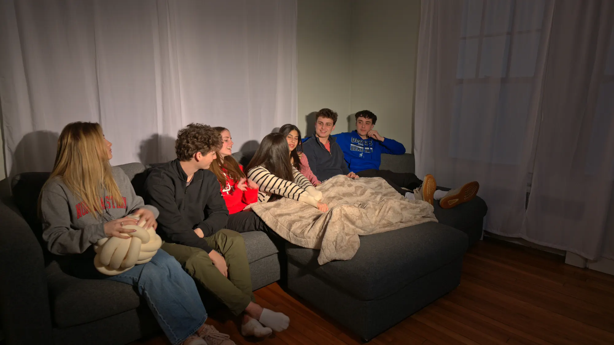 Housemates gathered on a sofa to watch television.