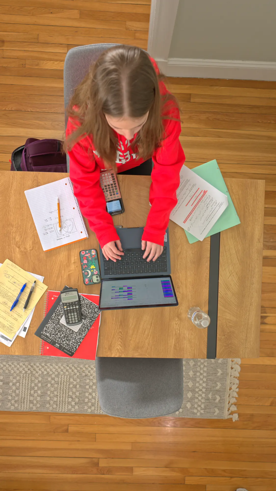 Overhead view of a student working at a dining table.