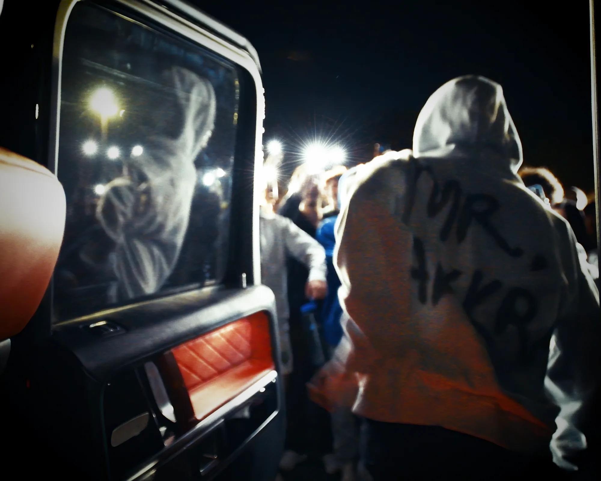 TAKKRA founder stepping from a car into a crowd gathered outside at night.