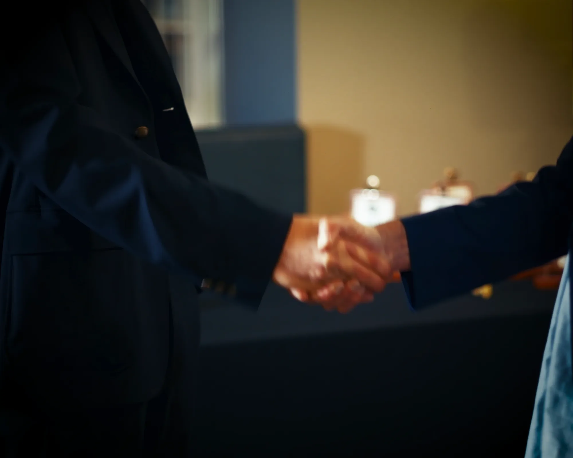 Two people shaking hands at the close of the TAKKRA film.